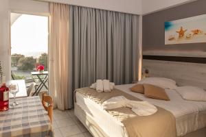 a bedroom with a bed and a table and a window at Irene Studios in Mastihari