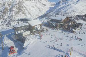 a group of people standing around a ski lodge in the snow at Azalea - Happy rentals in Livigno