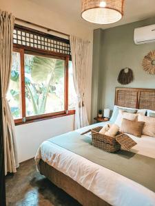 a bedroom with a bed with a large window at Greenhouse Siargao Eco-Beach Resort in General Luna