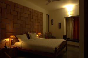 a bedroom with a large bed with a large wooden headboard at Nisargha Serviced Apartments in Bangalore