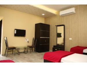 - une chambre avec un lit, une table et un miroir dans l'établissement Shubham Resorts, Solapur, à Solapur