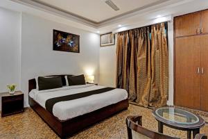 Schlafzimmer mit einem Bett und einem Glastisch in der Unterkunft Hotel VM Residency in Neu-Delhi