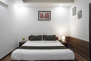 a bedroom with a large bed and two tables at Hotel VM Residency in New Delhi