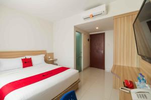 um quarto de hotel com uma cama e uma televisão em RedDoorz at Homestay Lotus 2 Pangkal Pinang em Pangkal Pinang