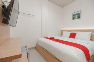 sypialnia z łóżkiem i telewizorem z płaskim ekranem w obiekcie RedDoorz at Homestay Lotus 2 Pangkal Pinang w mieście Pangkal Pinang
