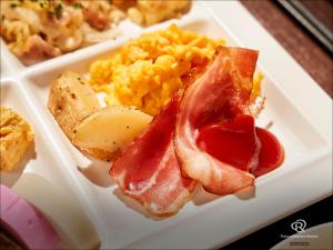 高松市にあるダイワロイネットホテル高松 のベーコンエッグとトーストを含む朝食用の食品