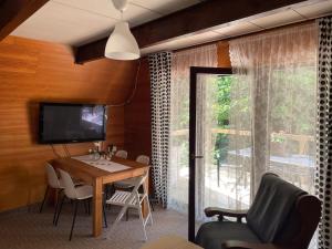 上貝奇瓦的住宿－Apartmány pod Rališkou，一间带桌子和电视的用餐室
