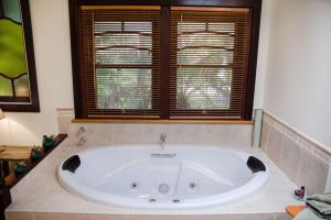 a bath tub in a bathroom with a window at Ashwood Cottages in Bright