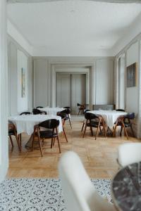 a room with tables and chairs in a room at Hôtel Les Séquoias in Ruy