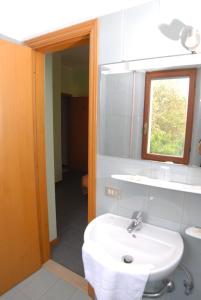 a bathroom with a white sink and a mirror at Hotel Del Duca in Montedinove