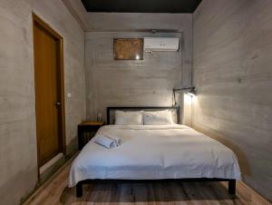 1 dormitorio con 1 cama blanca grande. en 40Inn Backpackers Warehouse en Taitung