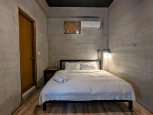 um quarto com uma grande cama branca em 40Inn Backpackers Warehouse em Taitung City