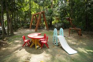 um parque infantil com uma mesa e cadeiras e um escorrega em VIRAMMA RESORT em Siliguri