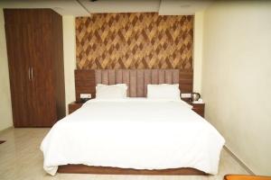 a bedroom with a large white bed in a room at VIRAMMA RESORT in Siliguri