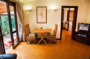 una camera con tavolo, sedie e televisore di Ashwood Cottages a Bright
