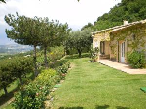 a house on a hill with a green yard at Sunny holiday home in Provence with pool in Séguret