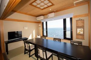 氷見市にあるLa-se-ri Resort & Stay - Vacation STAY 63364vのダイニングルーム(テーブル、椅子付)、大きな窓が備わります。