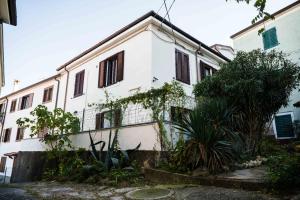 a white building with some plants in front of it at Marylin & Elvis in Muggia