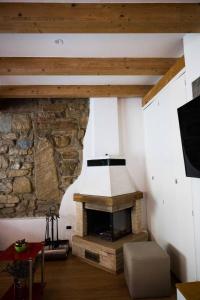 a fireplace in a room with a stone wall at Marylin & Elvis in Muggia