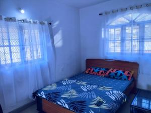 1 dormitorio con 1 cama con edredón azul y 2 ventanas en Beach ColvaPearl Luxury 3 BHK Villa, en Colva