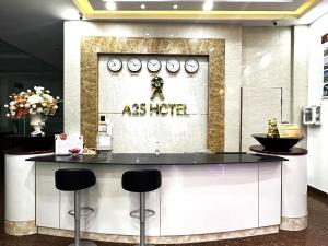 un restaurante con una barra con taburetes en una habitación en A25 Hotel -137 Nguyễn Du - Đà Nẵng, en Da Nang