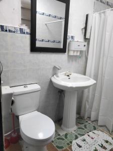 uma casa de banho com um WC branco e um lavatório. em SEASCAPE em Moalboal