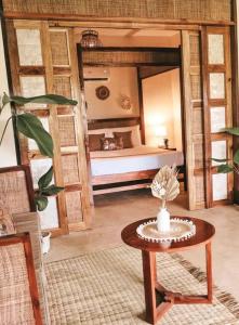 a room with a bed and a table in a room at Greenhouse Siargao Eco-Beach Resort in General Luna