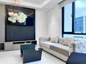 a living room with a couch and a flat screen tv at Puerto Santa Ana Luxury Suites Guayaquil in Guayaquil