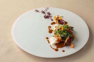um prato branco com um prato de comida numa mesa em Hotel Grand Bach Atami Crescendo em Atami