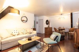 a living room with a couch and a table at La Loge by "Cosy Morning" Havre de Paix au Centre de Colmar, Idéal pour 4 Personnes in Colmar