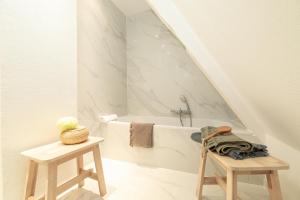 a bathroom with a bath tub and two tables at La Loge by "Cosy Morning" Havre de Paix au Centre de Colmar, Idéal pour 4 Personnes in Colmar