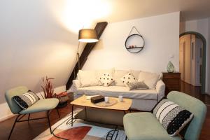 a living room with a couch and chairs and a table at La Loge by "Cosy Morning" Havre de Paix au Centre de Colmar, Idéal pour 4 Personnes in Colmar +12 photos