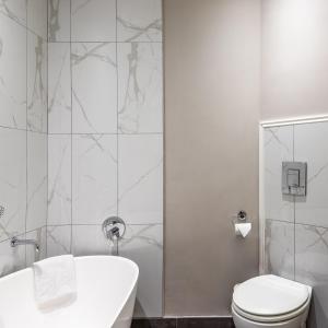 a bathroom with a tub and a toilet and a sink at Premier Express Inn George in George