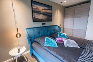 um sofá azul com almofadas na sala de estar em Ocean House Traum em Timmendorfer Strand