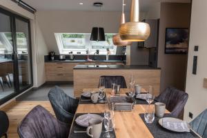 a dining room with a table and chairs and a kitchen at Wellness House Auszeit in Timmendorfer Strand