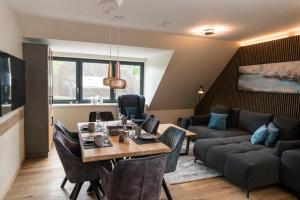 a living room with a table and a couch at Wellness House Auszeit in Timmendorfer Strand