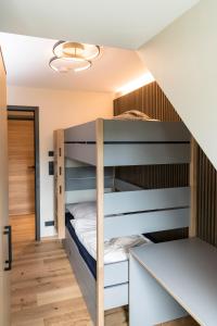 a bedroom with bunk beds and a staircase at Wellness House Auszeit in Timmendorfer Strand