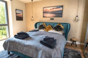 Un dormitorio con una cama azul con toallas. en Heaven House Harmonie, en Timmendorfer Strand