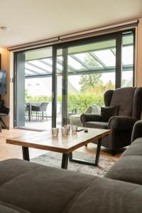 a living room with couches and a coffee table at Wellness House Energy mit Whirlpool in Timmendorfer Strand