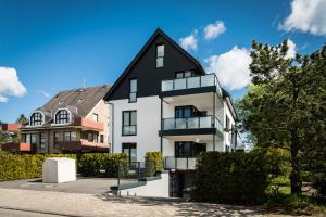 una gran casa blanca con techo negro en Baltic House Muschel, en Timmendorfer Strand