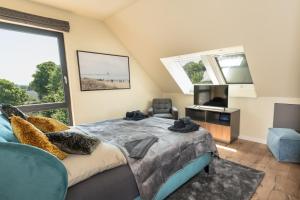 Schlafzimmer mit einem Kingsize-Bett und einem TV in der Unterkunft Heaven House Penthousewohnung Sterngucker mit Whirlpool in Timmendorfer Strand