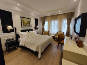 a bedroom with a large bed and a living room at Peerless Hotel Kolkata in Kolkata +64 photos