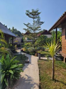 a walkway in a garden next to a house at Mister check paradise in Si Chiang Mai