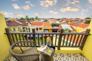 a balcony with a chair and a view of a city at Villa Soleil Hoi An in Hoi An