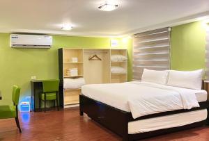 達古潘的住宿－Damara Hotel at Ciudad Elmina，一间卧室设有一张床和绿色的墙壁