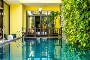 會安的住宿－Villa Soleil Hoi An，植物群前的游泳池