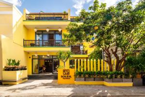 會安的住宿－Villa Soleil Hoi An，前面有销售标志的黄色建筑