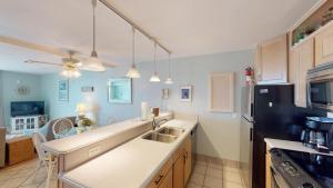 a kitchen with a sink and a black refrigerator at VILLA 315 - The Eagles Nest condo in Jekyll Island