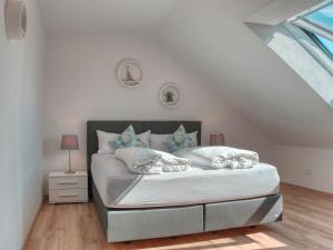 um quarto com uma cama com lençóis brancos e almofadas em Ferienhaus Stäffele em Überlingen