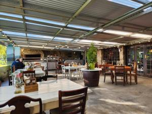 un restaurante con mesas y sillas en una habitación en Portland Manor, en Rheenendal